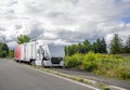 Broken Big rig white semi truck with open hood and with semi trailer standing on the road shoulder trying to fix a breakdown in Royalty Free Stock Photo