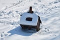 Broken bird house fallen on the ground in fresh snow, on bright sunny Winter day. Close up Royalty Free Stock Photo