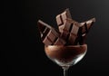 Broken black chocolate bar in glass with cocoa powder Royalty Free Stock Photo