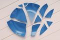 broken blue plate is on table, broken-down dish, crushed tableware is on white background,