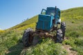 Broken blue tractor on a green hill Royalty Free Stock Photo