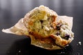 Broken blueburry muffin on baking paper on black wooden Royalty Free Stock Photo