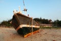 A broken boat is lying on the sand of the beach Royalty Free Stock Photo