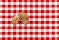 Broken bread laid flat on an nostalgic red / white checkered tablecloth