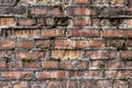 Broken brick wall background in sunny summer day. Abstract red brick old wall texture background. Ruins uneven crumbling red brick Royalty Free Stock Photo