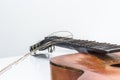 Broken brown classical guitar with detached bridge from body isolated