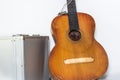 Broken brown classical guitar with detached bridge from body in white background