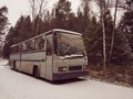 Broken Bus Abandoned in the Snow. Old forgotten gray bus on frosty road in woods. landscape with abandoned bus by the road side in