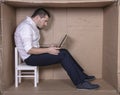 Broken businessman in a cardboard office, stress and depression from overwork