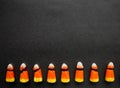 Broken candy corn look like small bad teeth. Black background. Copy space. Halloween harmful sweets concept Royalty Free Stock Photo