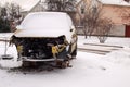 Broken car after an accident under the snow. Consequences of violation of traffic rules