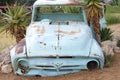 Empty blue car as garden decoration in Namibia, rusty abandoned car in sand dunes of Namibia