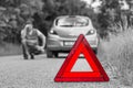 Broken car on the road and unhappy driver with red triangle Royalty Free Stock Photo