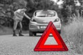 Broken car on the road and unhappy driver with red triangle Royalty Free Stock Photo