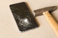 A broken cell phone and hammer on grey background Royalty Free Stock Photo