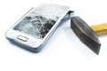 Broken cell phone with a hammer on a white background Royalty Free Stock Photo