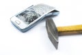 Broken cell phone with a hammer on a white background Royalty Free Stock Photo