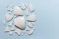 Broken ceramic porcelain pieces on blue background