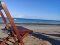 Broken chair on the beach and a boat behind Royalty Free Stock Photo