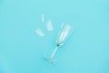 Broken champagne glass with splinters on blue background with copy space. Concept fight against alcoholism, drunkenness and