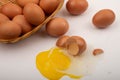 A broken chicken egg, chicken eggs in a wicker basket and chicken eggs scattered on a white background. Close up Royalty Free Stock Photo