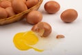 A broken chicken egg, chicken eggs in a wicker basket and chicken eggs scattered on a white background. Close up Royalty Free Stock Photo