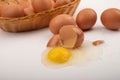 A broken chicken egg, chicken eggs in a wicker basket and chicken eggs scattered on a white background. Close up Royalty Free Stock Photo