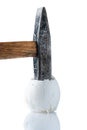 A broken chicken egg and a hammer on a white background Royalty Free Stock Photo