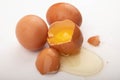 A broken chicken egg and several eggs on a white background. Country food. Close up Royalty Free Stock Photo