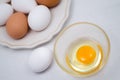 Broken chicken egg and white and brown eggs on the plate Royalty Free Stock Photo