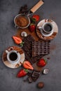 Broken chocolate blocks with strawberries and 2 cups of coffee o Royalty Free Stock Photo