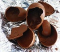 Broken chocolate Easter egg on a foil sheet Royalty Free Stock Photo