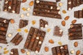 Broken chocolate pieces with nuts and raisins on a stone background top view Royalty Free Stock Photo