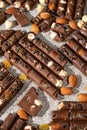Broken chocolate pieces with nuts and raisins on a stone background top view Royalty Free Stock Photo