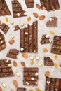 Broken chocolate pieces with nuts and raisins on a stone background top view Royalty Free Stock Photo