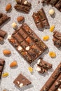 Broken chocolate pieces with nuts and raisins on a stone background top view Royalty Free Stock Photo