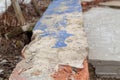 Broken concrete surface on the bricks with the blue paint coming off