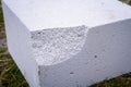 Broken corner of aerated concrete brick close-up. Impacted aerated concrete block. fragile building material