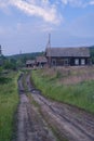 broken country road and old Russian wooden village house Royalty Free Stock Photo