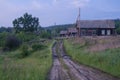 broken country road and old Russian wooden village house Royalty Free Stock Photo