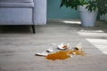 A broken cup of coffee fell on laminate, coffee spilled on floor Royalty Free Stock Photo