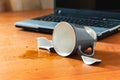 Broken cup and spilled tea or coffee near laptop in the office Royalty Free Stock Photo