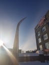 Broken curved barrier against the blue sky and the building