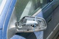 Broken and damaged side mirror on the blue car doors with remaining wires holding plastic frame without glass Royalty Free Stock Photo