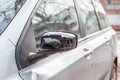 Broken and damaged side mirror on the car doors with remaining wires holding plastic frame without glass Royalty Free Stock Photo