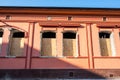 Broken and damaged windows with hole in the facade of the house or building waiting to be replaced closed and secured with wooden Royalty Free Stock Photo