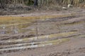 Broken dirt road after heavy rain. Swampy lagoon of a road demonstrates the most common problem in maintaining rural roads Royalty Free Stock Photo