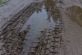 Broken dirt road after heavy rain. Swampy lagoon of a road demonstrates the most common problem in maintaining rural roads Royalty Free Stock Photo