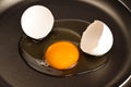 Broken egg on black pan Royalty Free Stock Photo