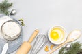 Broken egg in bowl, whisk and sieve, flour and sprigs of fir on table Royalty Free Stock Photo